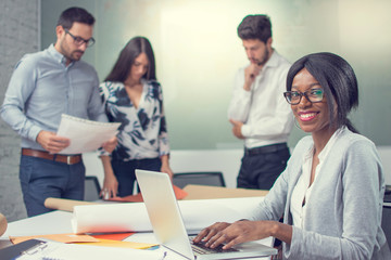 Smiling business woman working using laptop in office