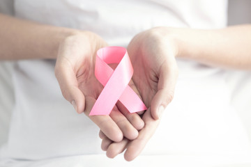 Pink ribbon in hands