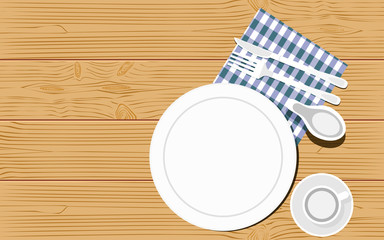 Top view of kitchenware on wooden background. Empty dishes with fork, knife and kitchen towel. Copy space.