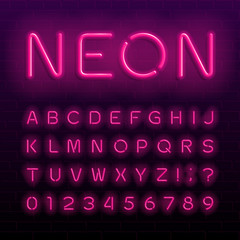 Neon lamp alphabet font. Neon color shiny letters, numbers and symbols. Brick wall background. Stock vector typeface for any typography design.