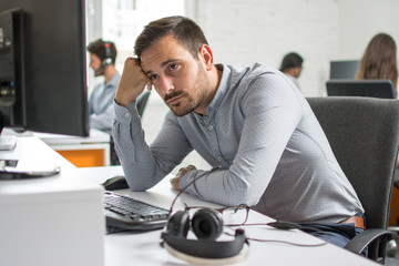 Worried beard man looking at computer screen in office