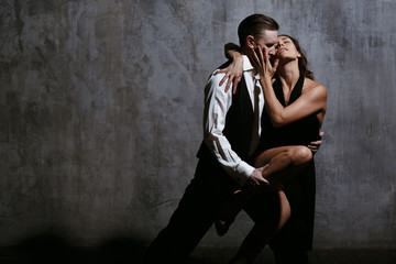 Young pretty woman in black dress and man dance tango - obrazy, fototapety, plakaty