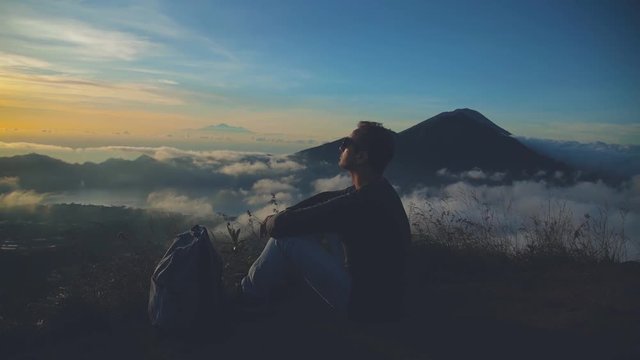 Man watching the sunrise from mount Batur, Bali - Indonesia.