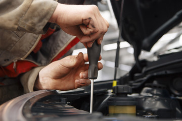 Mechanic with new car headlight in a workshop