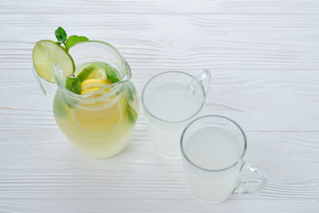 Citrus lemonade and lime water with lemon sliced , healthy and detox water drink in summer on white wooden table