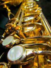 Obraz na płótnie Canvas Old golden saxophone close-up. Beautiful vintage shiny brass jazz musical instrument.