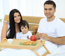 Family having breakfast in bed at home