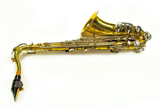 Old golden saxophone on white background.
Beautiful vintage shiny brass jazz musical instrument.