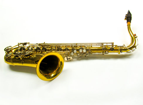 Old golden saxophone on white background.
Beautiful vintage shiny brass jazz musical instrument.