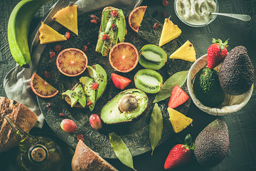 Assorted fruits on a plate. Avocados, blood oranges, kiwis, pineapple and strawberries