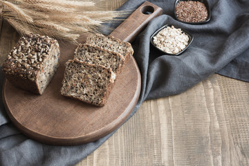 A loaf of fresh rustic rye bread on wooden board. Healphy food background. Close up. Copy space. Fitness wholegrain bread.