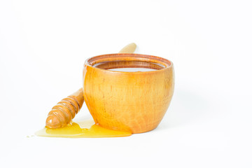 Honey in a wooden bowl and a honey dipper.