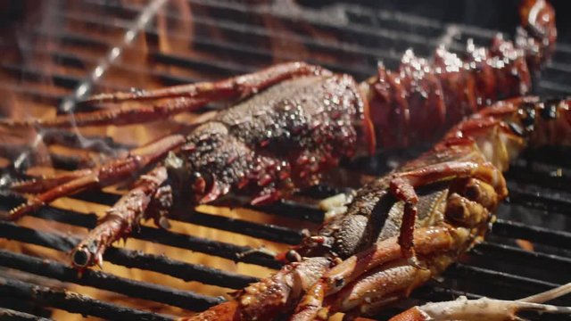 Pouring oil onto crayfish on a flaming barbecue, 