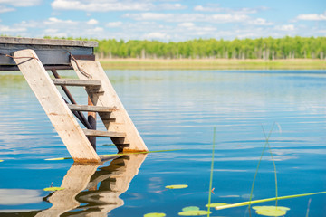 authentic wooden staircase and pier near a picturesque pond close up