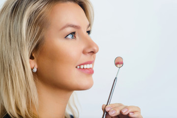 Healthy woman teeth and a dentist mouth mirror close up macro picture