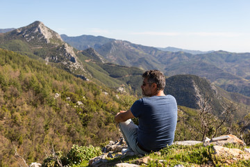 Naklejka na ściany i meble Traveller man looking at mountain landscape