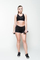 Woman in sports clothes with dumbbells isolated on white