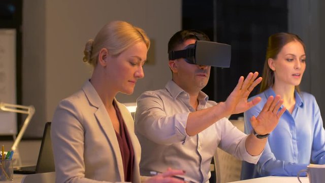 team with virtual reality headset at night office