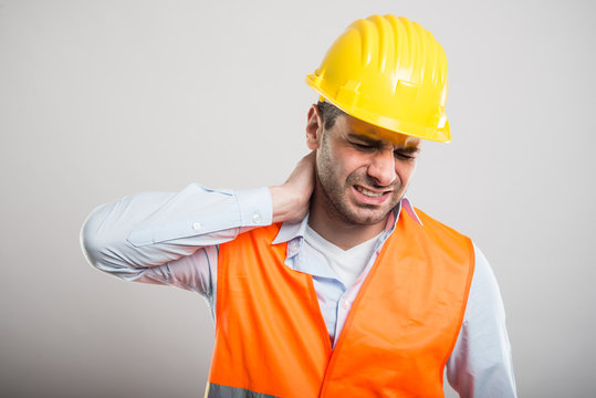 Portrait of young architect holding neck like in pain