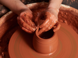 production process of pottery. Forming a clay teapot on a potter's wheel.