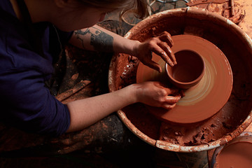 production process of pottery. Forming a clay mug on a potter's wheel.