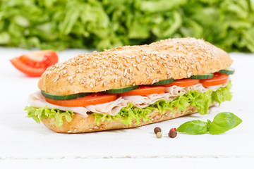 Sandwich Baguette Vollkorn Brötchen belegt mit Schinken auf Holzbrett