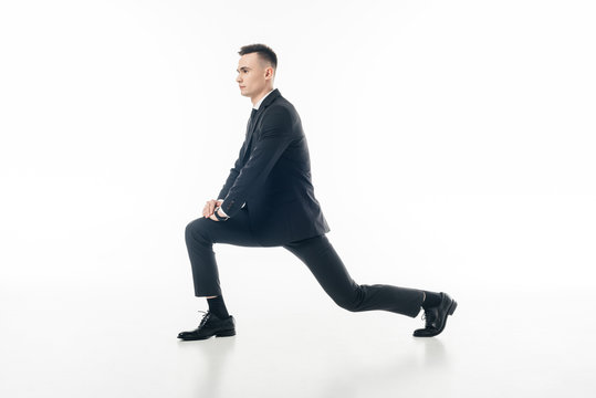 businessman stretching legs in suit isolated on white