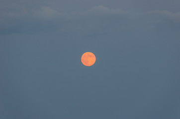 Fotografía de la luna llena naranja al anochecer.