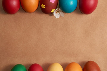 Frame colorful Easter eggs on brown background