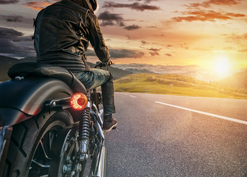 Fototapeta Motorcycle rider ready for drive in Alps, beautiful sunset sky