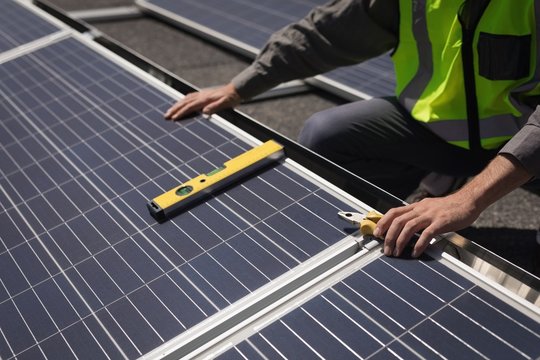 Male worker working on solar panels at solar station