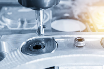 The CNC milling machine cutting the automobile  part by solid ball end-mill  tool in light blue scene  with lighting effect.