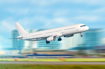 Climbing take off aircraft jet on a city building background.
