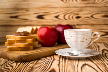 Breakfast toasts with jam on plate and cup of tea on wooden background