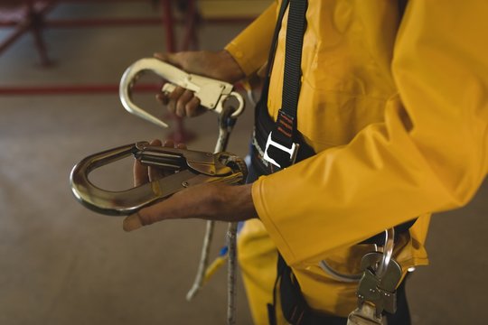 Male worker holding carabiner at solar station