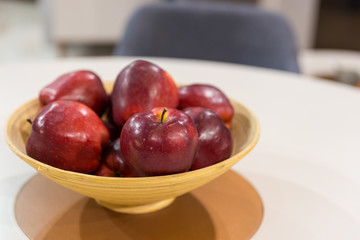 Red apples on wooden plate