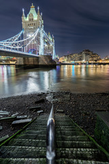 Stufen führen zum Ufer an der Themse mit Sicht auf die Tower Bridge in London am Abend