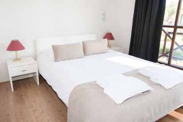 Fototapeta na wymiar hotel resort bedroom with large bed and windows