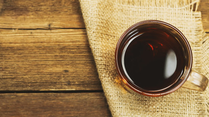 tea in a cup on a wooden background.