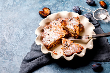Plum Pie in the Ceramic Shape. Homemade Sweet Dessert. Bake on the Blue Background.