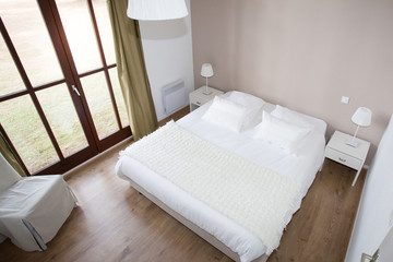 Fototapeta na wymiar large bed in home bedroom with wood floor