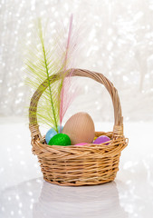 påskägg i en korg på vitt bord