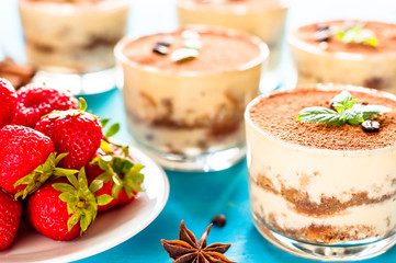 Homemade italian dessert tiramisu with strawberries and mint in glass