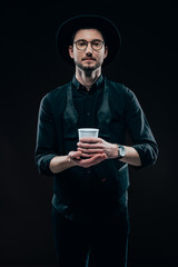 Man in black clothes holding coffee cup isolated on black