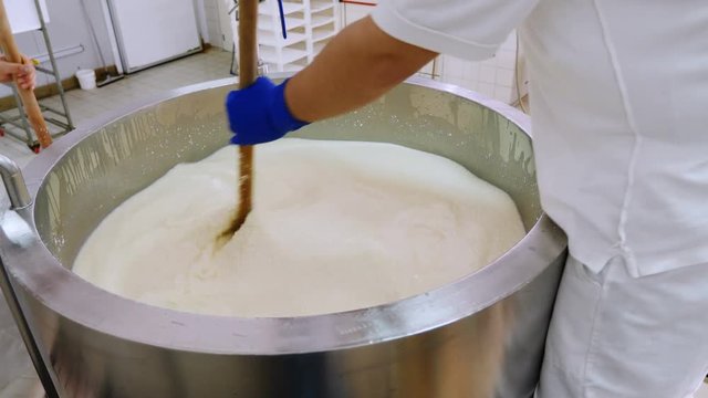 Cheese Prodution- operators mixing milk in the cauldron