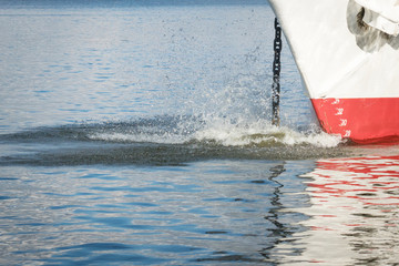 the ship's anchor goes into the water with splashes