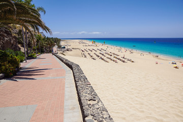 Fototapeta premium Sand dune and coastal promenade along a beach in Morro Jable town, Fuerteventura, Canary Islands, Spain