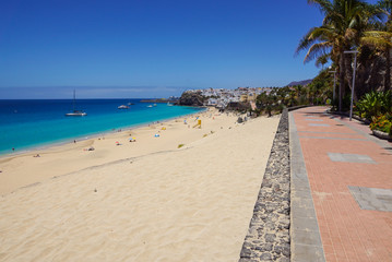 Promenade with tropical plants and flowers along a beach in Morro Jable holiday village, Fuerteventura, Canary Islands, Spain