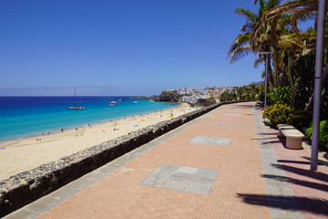 Promenade with tropical plants and flowers along a beach in Morro Jable holiday village, Fuerteventura, Canary Islands, Spain