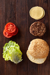 Tasty hamburger ingredients are laid out separately from above, beautifully harmoniously, close-up, top view